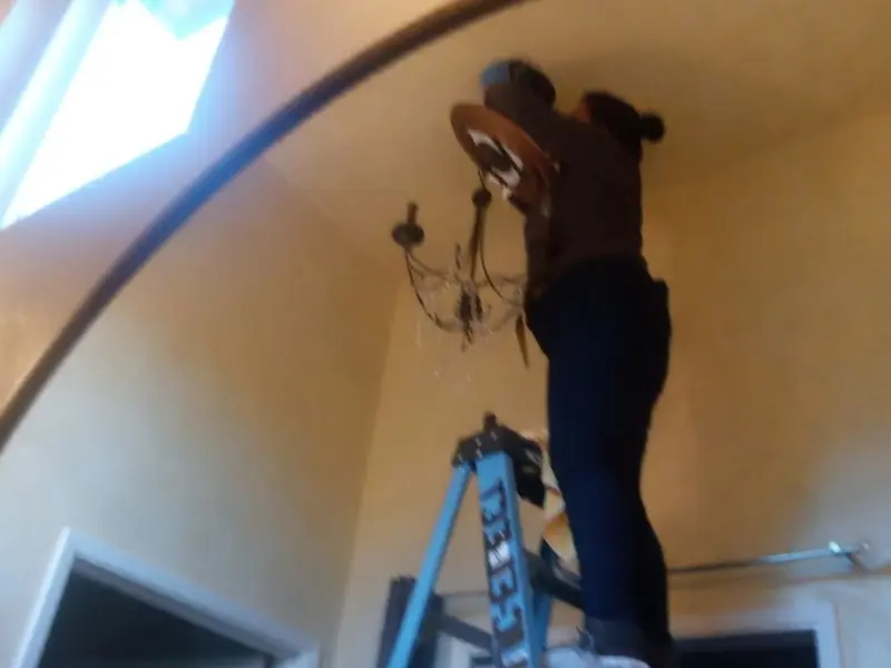 Electrician installing a chandelier in a Drum Point residence
